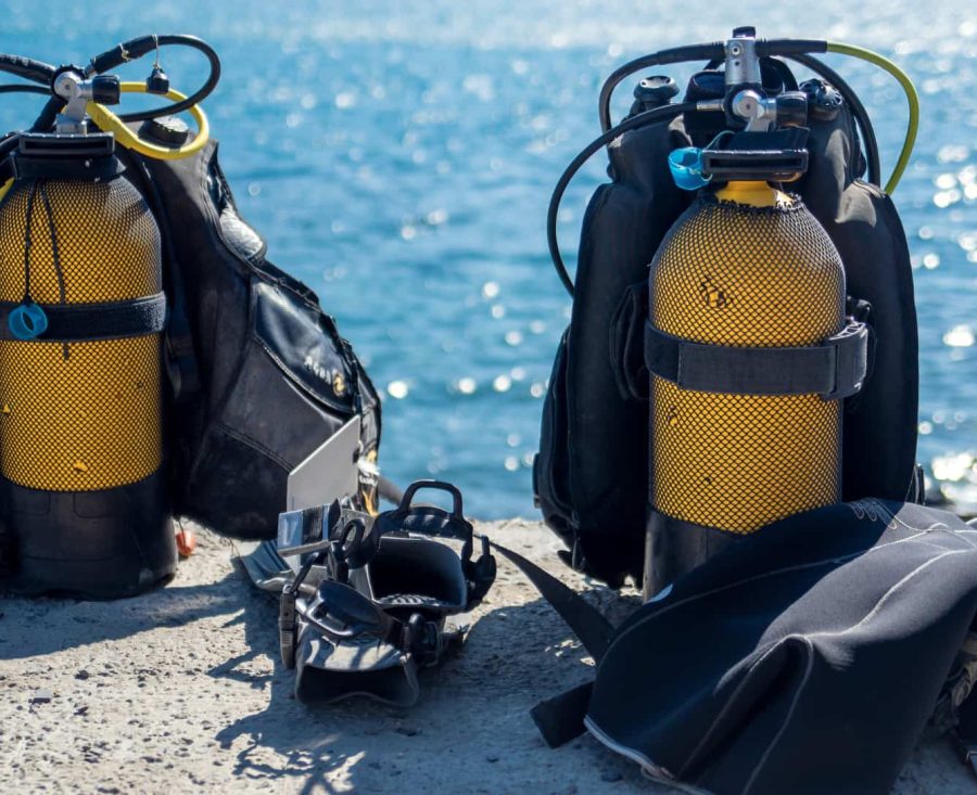 Equipo de tanques de buceo preparado en la playa. Material de buceo listo para inmersión.